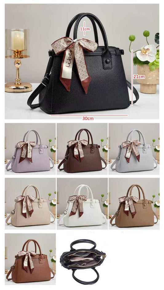 Bolso de mano con textura y un pañuelo de seda atado al asa