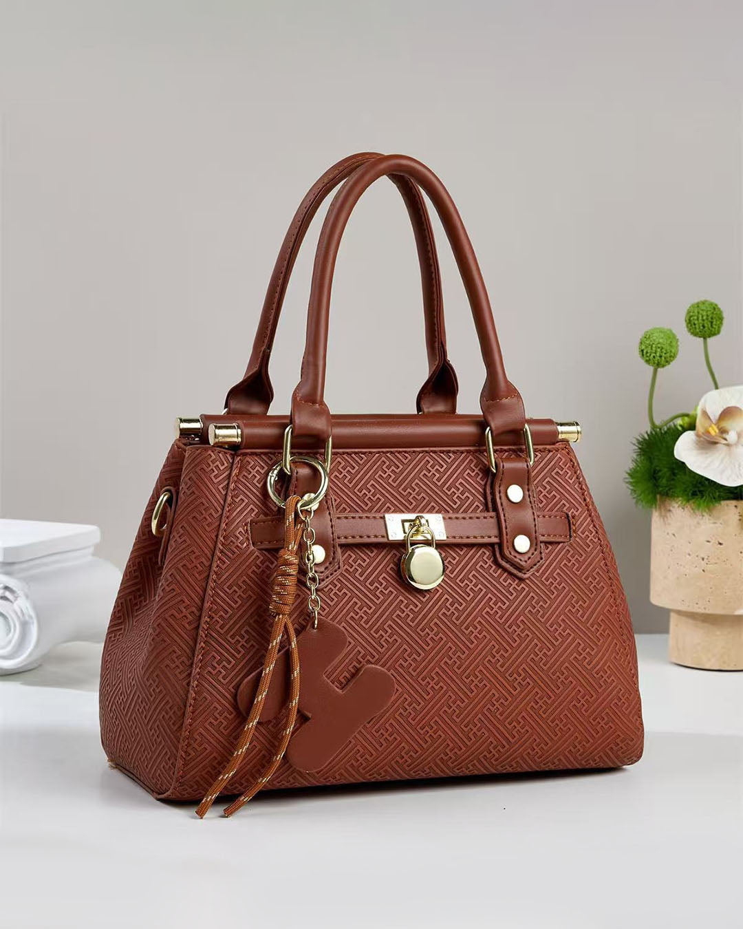 Bolso pequeño de mano con patrón geométrico grabado