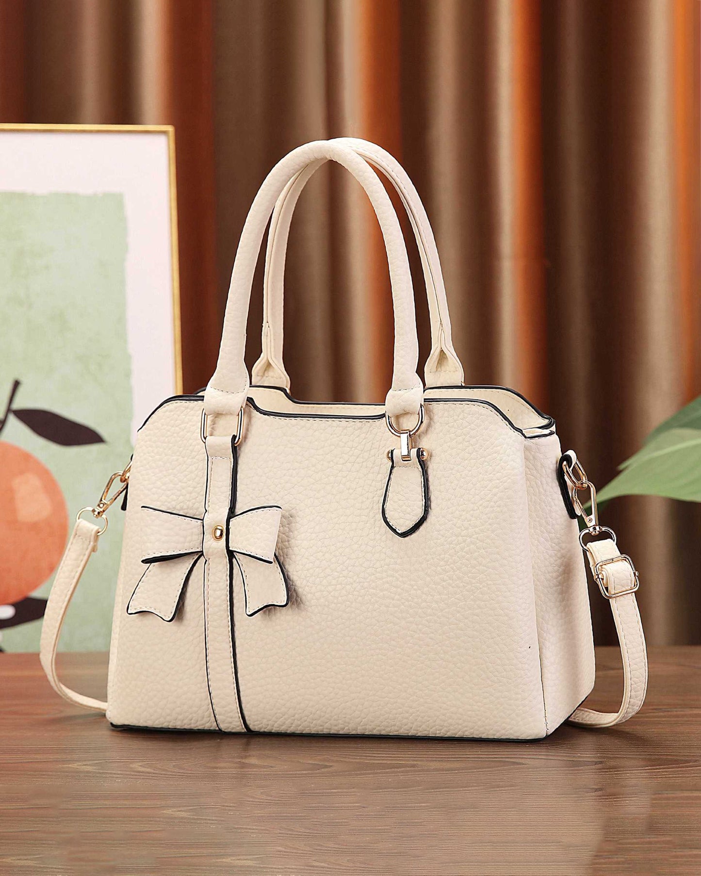 Cartera de mano en tamaño mediano con lazo frontal decorativo