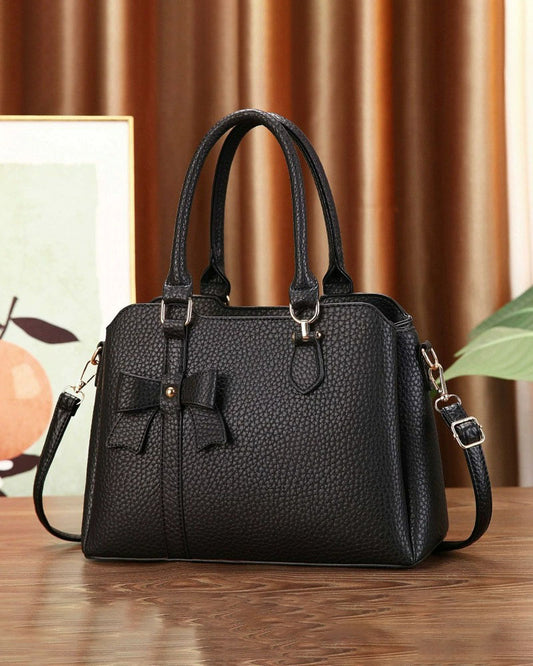 Cartera de mano en tamaño mediano con lazo frontal decorativo