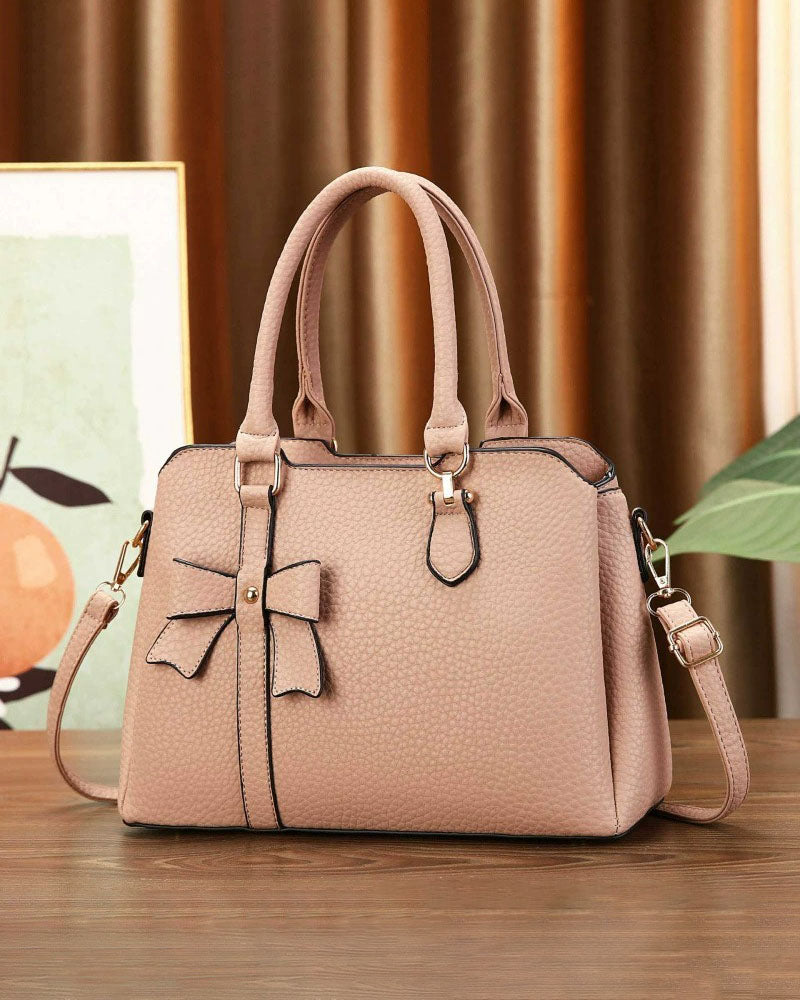 Cartera de mano en tamaño mediano con lazo frontal decorativo