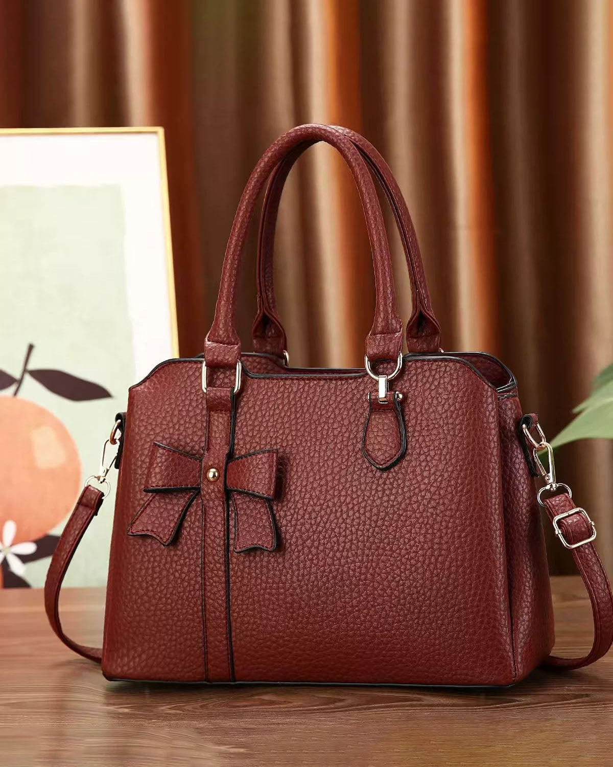 Cartera de mano en tamaño mediano con lazo frontal decorativo