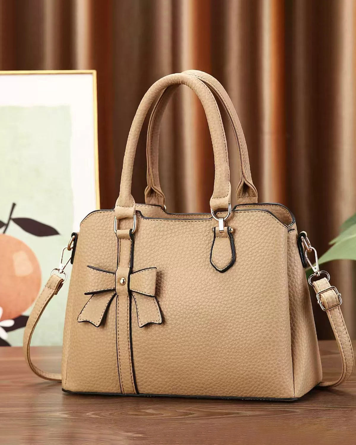 Cartera de mano en tamaño mediano con lazo frontal decorativo
