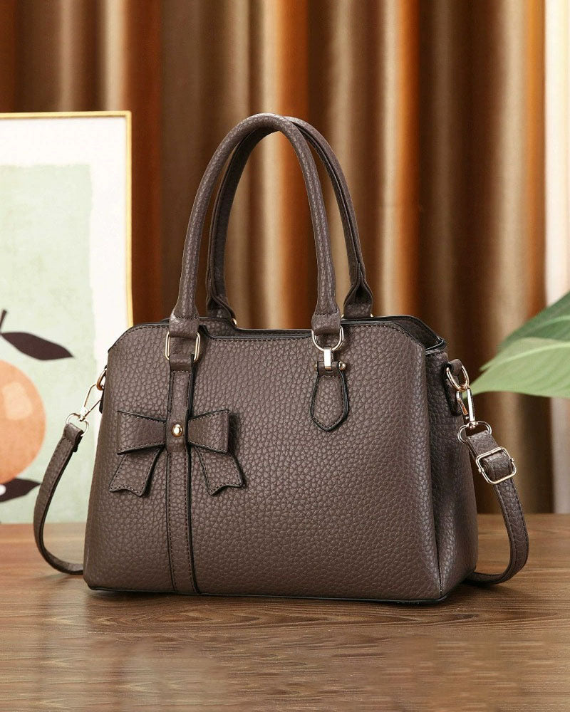 Cartera de mano en tamaño mediano con lazo frontal decorativo