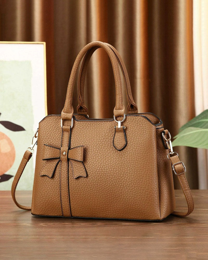 Cartera de mano en tamaño mediano con lazo frontal decorativo