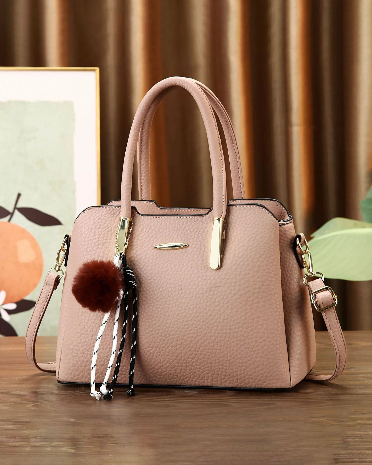 Cartera mediana con colgante y detalles en dorado