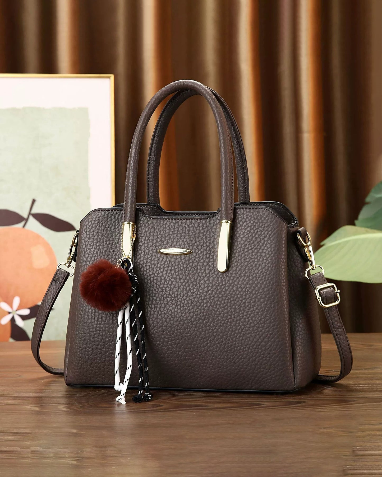 Cartera mediana con colgante y detalles en dorado