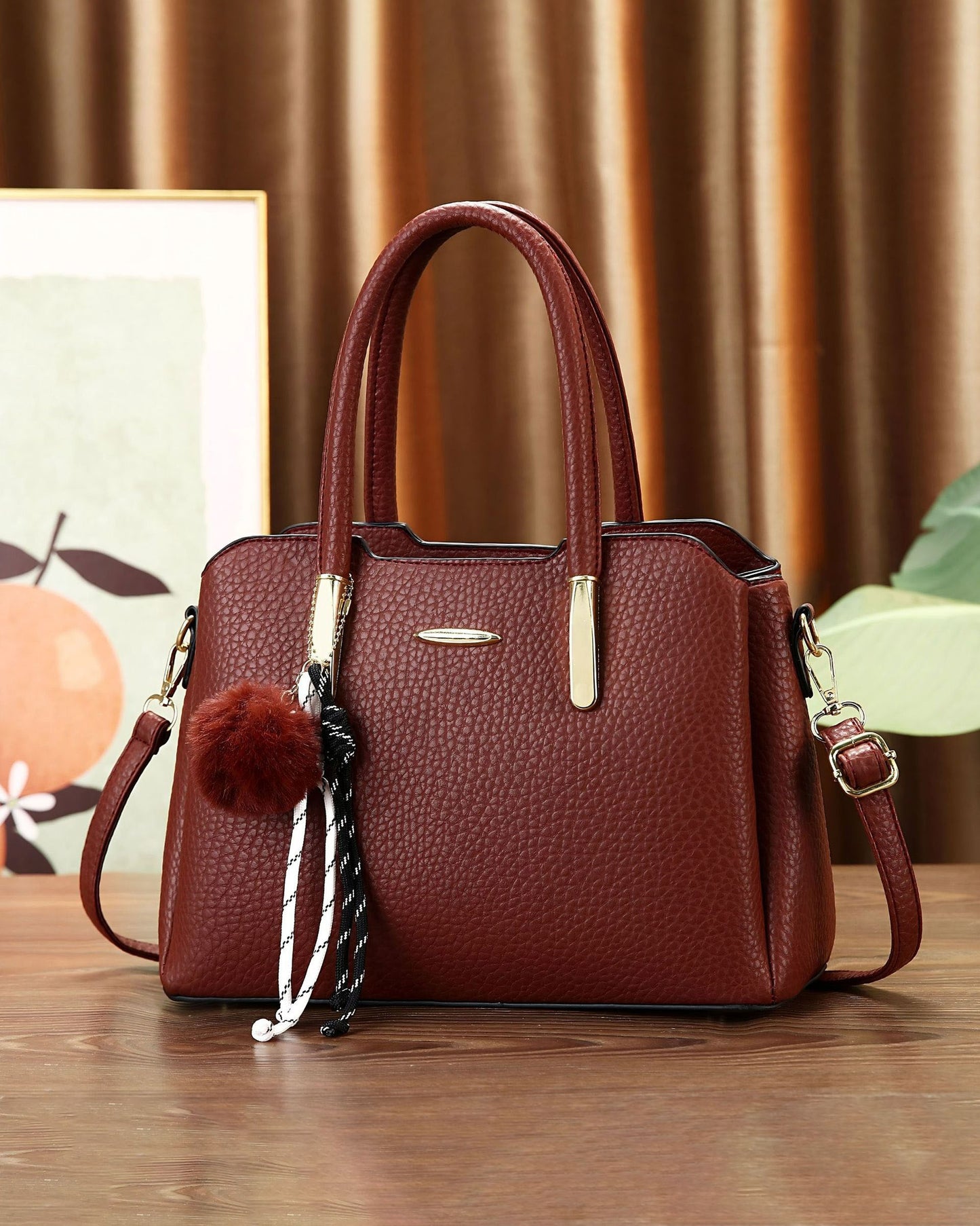 Cartera mediana con colgante y detalles en dorado