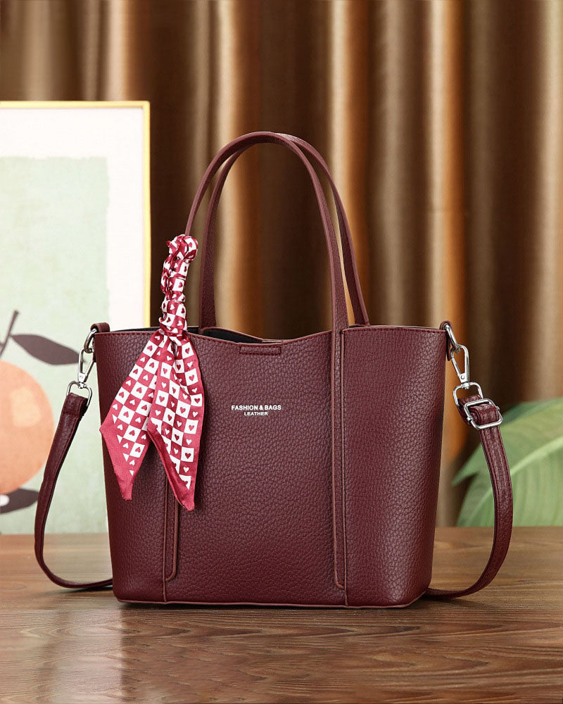 Cartera de mano con correa cruzada y pañuelo decorativo