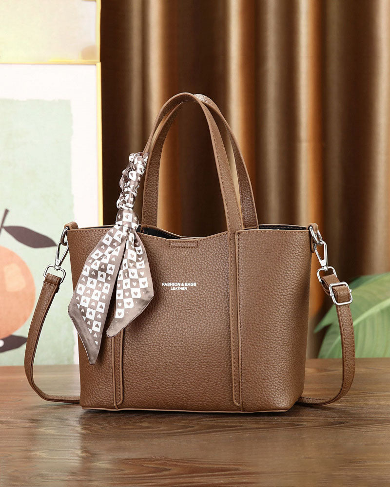 Cartera de mano con correa cruzada y pañuelo decorativo
