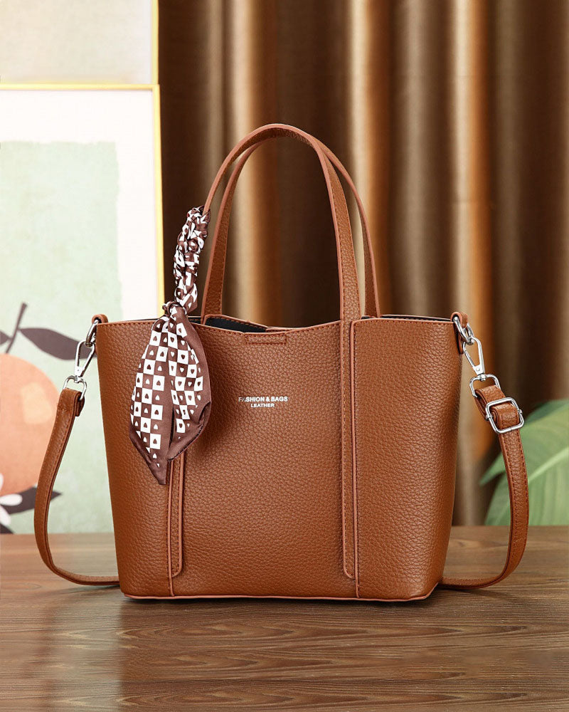 Cartera de mano con correa cruzada y pañuelo decorativo
