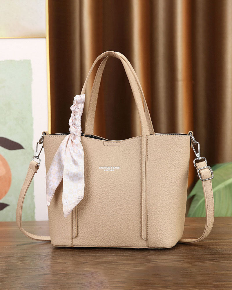 Cartera de mano con correa cruzada y pañuelo decorativo