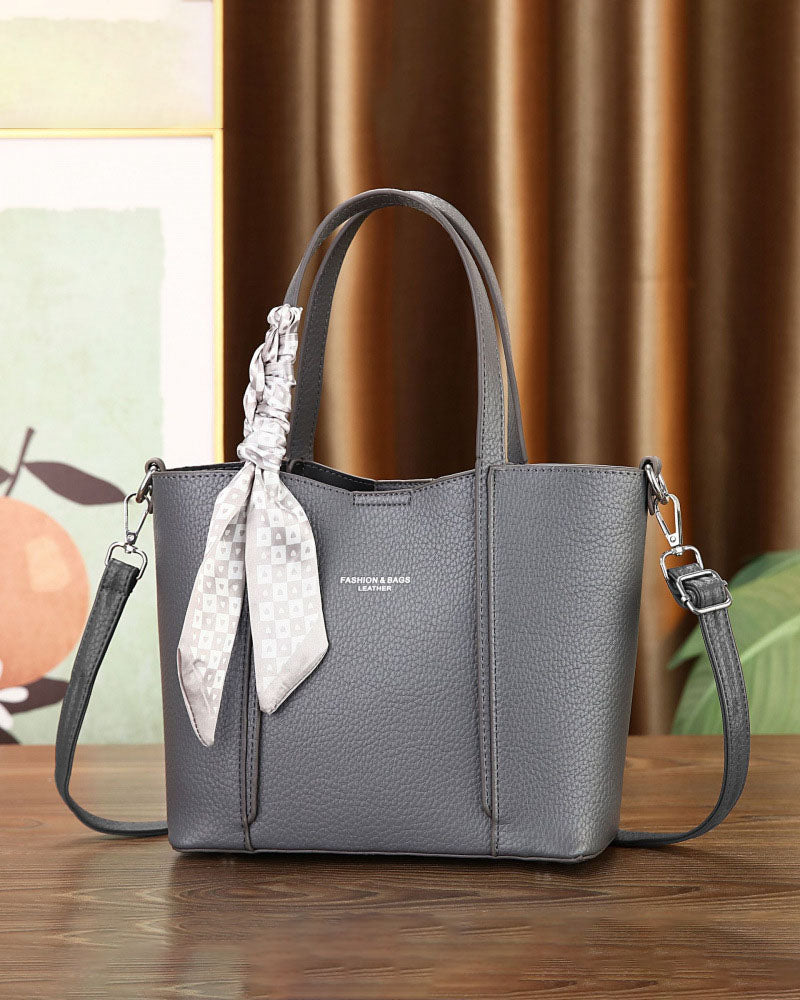 Cartera de mano con correa cruzada y pañuelo decorativo