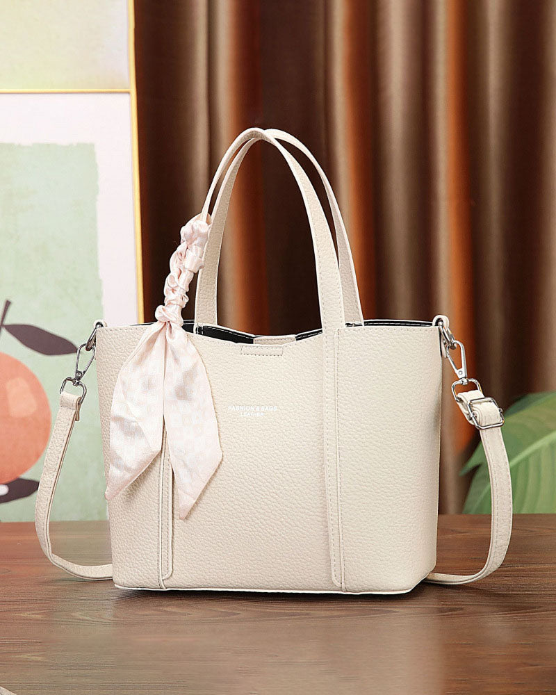 Cartera de mano con correa cruzada y pañuelo decorativo