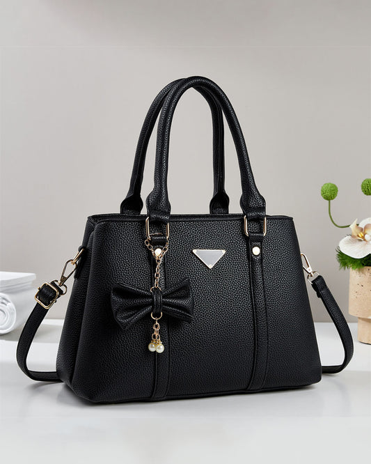 Cartera mediana con colgante de lazo y detalles en dorado