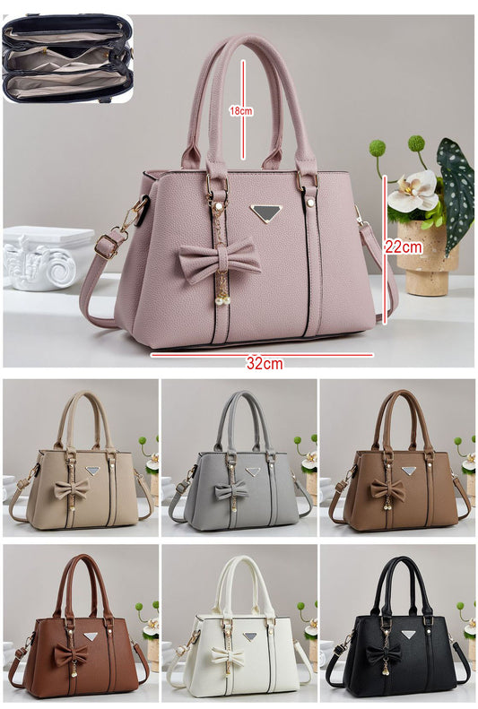 Cartera mediana con colgante de lazo y detalles en dorado