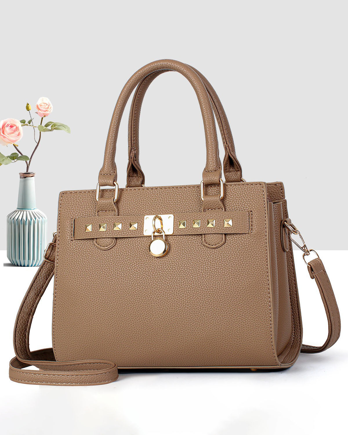Cartera mediana de mano con detalles y tachuelas frontales en dorado