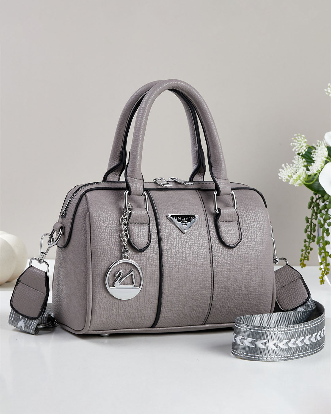 Cartera pequeña tipo baul con detalles en plateado