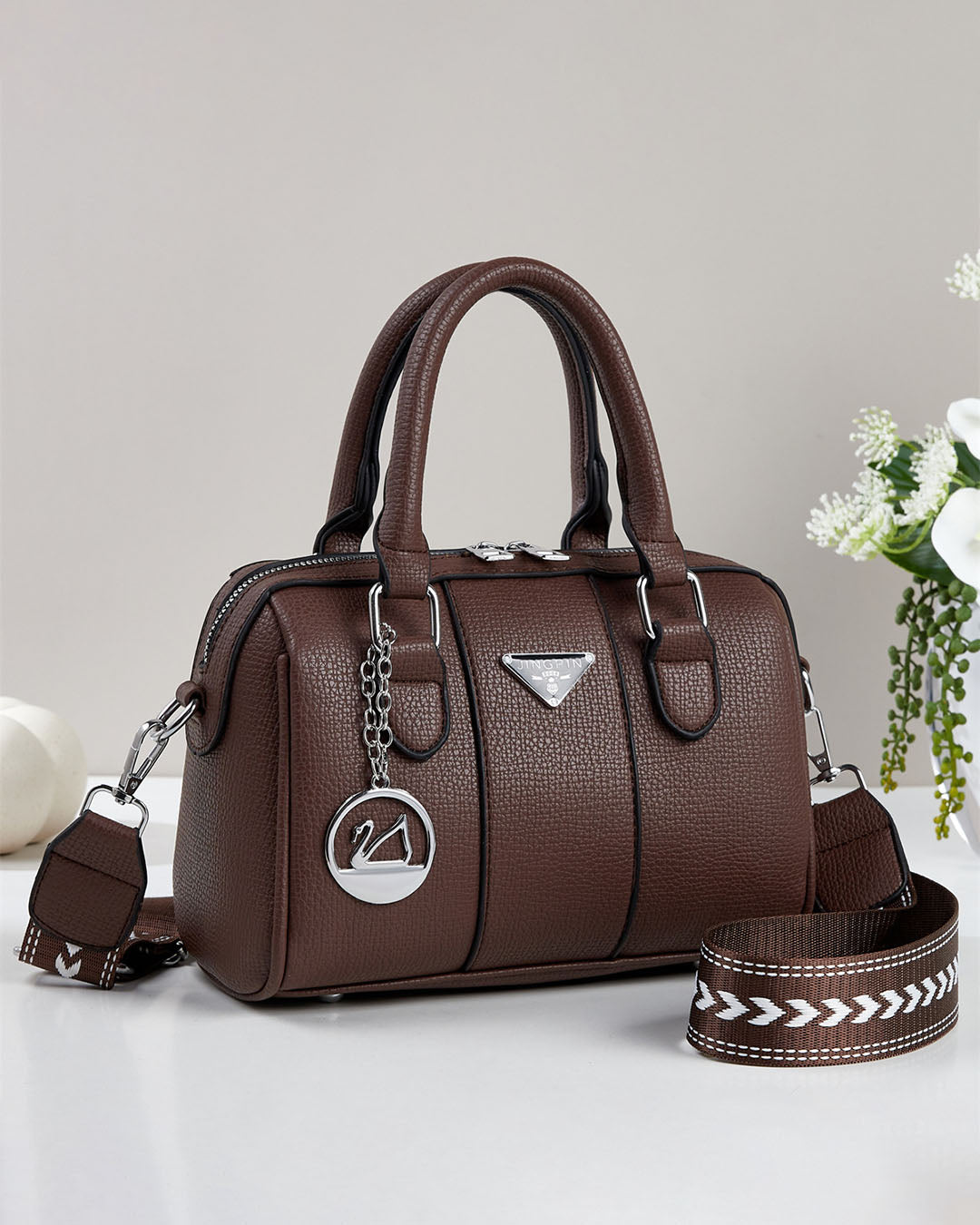 Cartera pequeña tipo baul con detalles en plateado