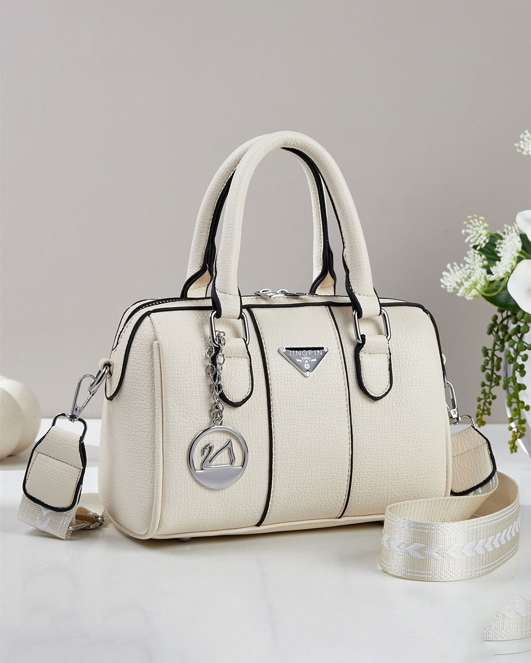 Cartera pequeña tipo baul con detalles en plateado