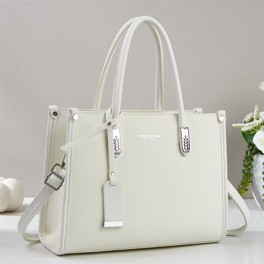 Cartera mediana con forma cuadrada y detalles plateados
