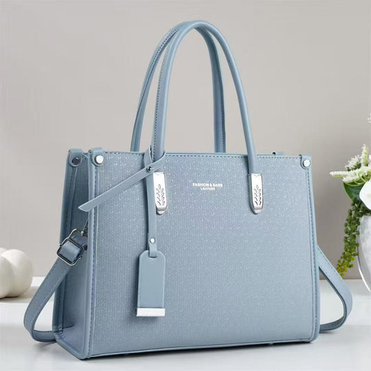 Cartera mediana con forma cuadrada y detalles plateados